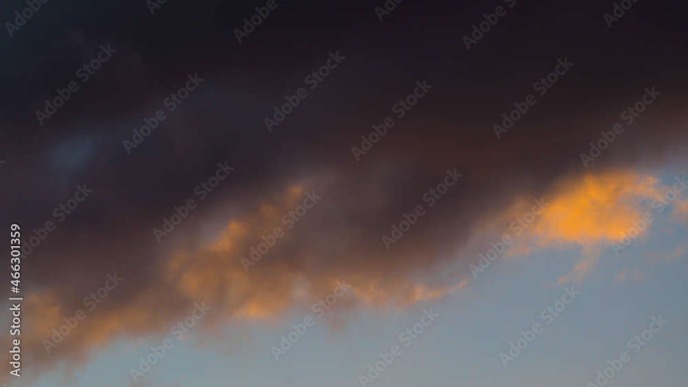 Ciel jaunâtre sous des nuages de basse altitude, pendant le coucher du soleil