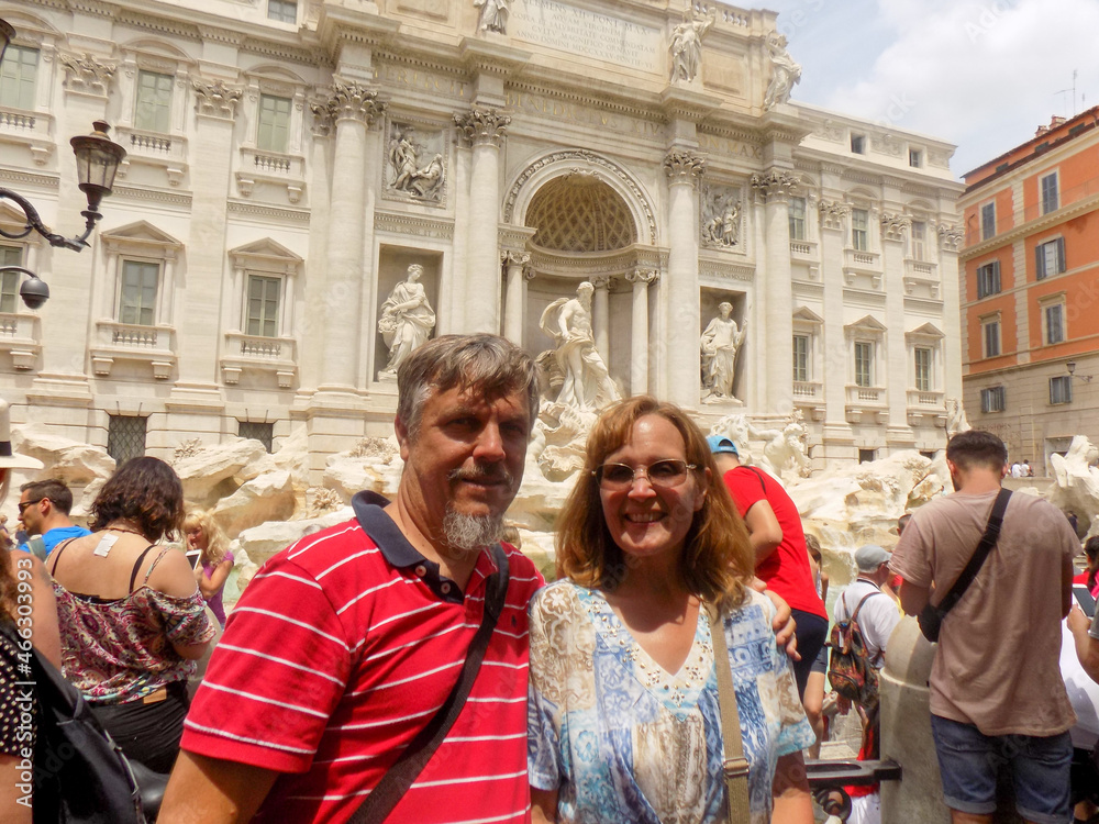 The Famous Trevi Fountain in Rome Italy with a Mature Married Couple Posing in front of the Crowd
