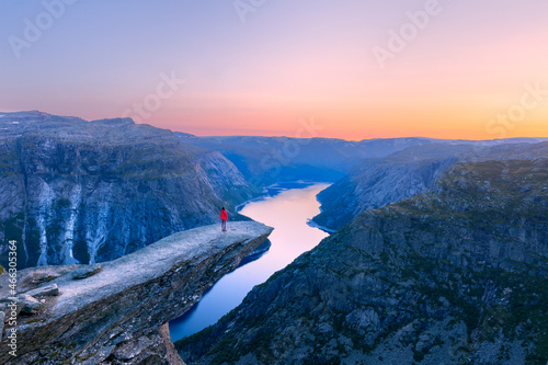 Alone tourist on Trolltunga rock - most spectacular and famous scenic cliff in Norway photo