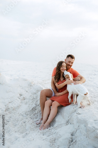 young couple in orange clothes with dog