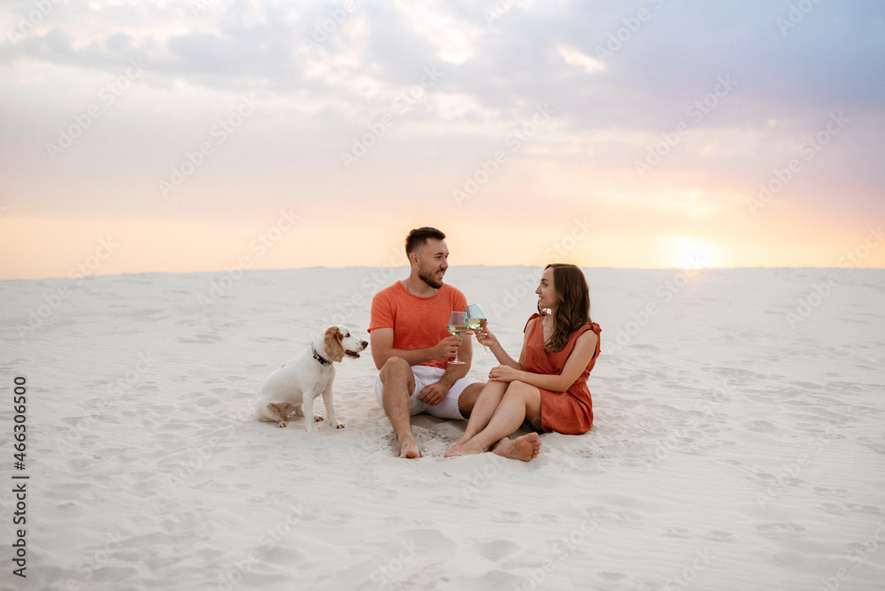 young couple in orange clothes with dog young couple in orange clothes with dog