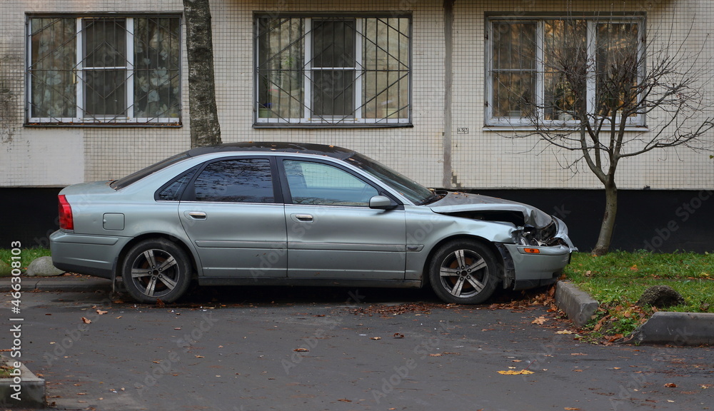 A broken light passenger car is parked in the courtyard of a residential building, Dybenko street, St. Petersburg, Russia, October 2021
