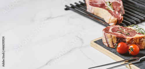 Obraz na płótnie three delicious steaks ready to grill on a white marble surface w salonie