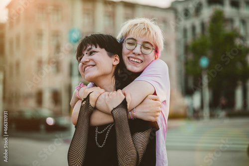 Young gender fluid couple hugging on city street
 photo