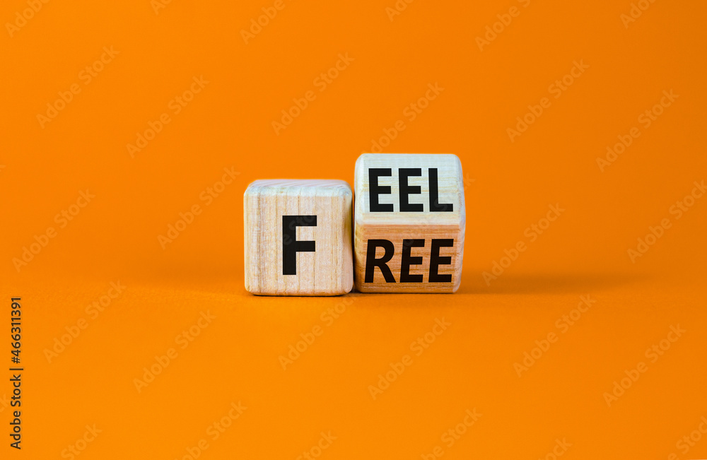 Feel free symbol. Turned a wooden cube with concept words 'Feel free' on a beautiful orange table, orange background. Copy space. Psychology and feel free concept. Feel free symbol. Turned a wooden cube with concept words 'Feel free' on a beautiful orange table, orange background. Copy space. Psychology and feel free concept.