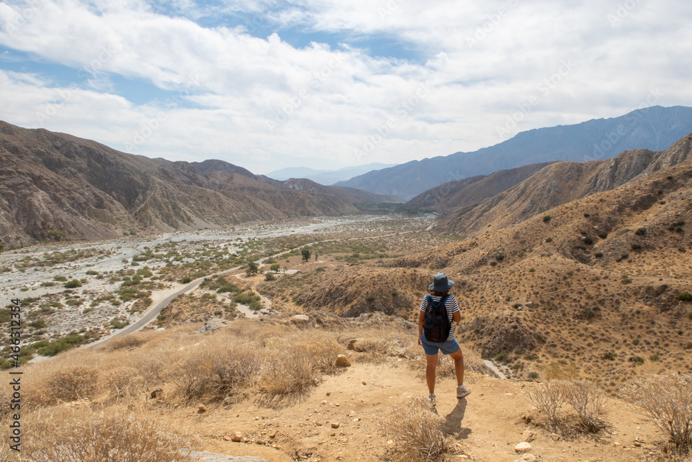 A Woman Hiker Exploring and Overlooking  the California Desert Whitewater River Valley from the Trail Above