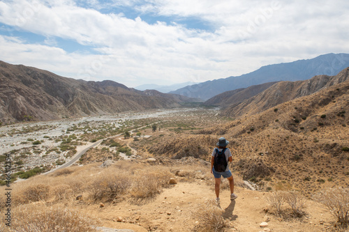 A Woman Hiker Exploring and Overlooking the California Desert Whitewater River Valley from the Trail Above