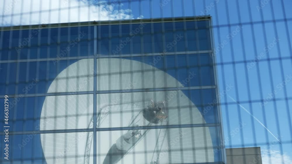 Reflejo de una antena en el cristal de un edificio. 