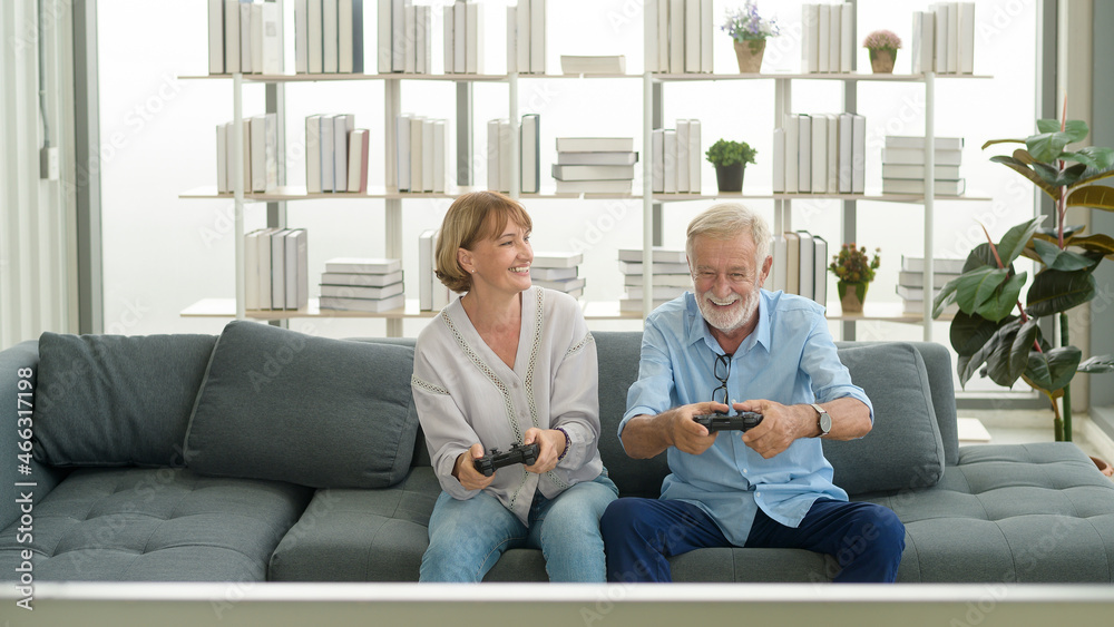 Happy Caucasian senior couple playing games at home
