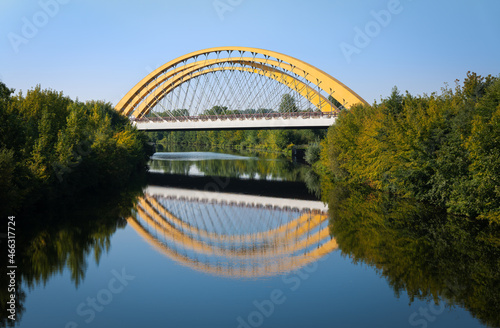 The arched bridge on the western Berliner Ring over the Havel Canal near Brieselang. It is a sunny day. The bridge is reflected in the water. photo
