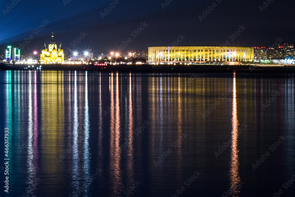 The illumination of the city is reflected in the water at night