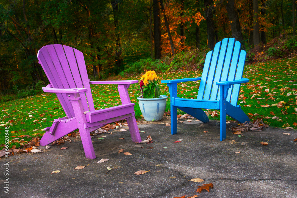 Adirondack chairs sit on a patio in Autumn in Hershey PA. Purple and Blue Chairs look inviting this nice Autumn Day. Adirondack chairs sit on a patio in Autumn in Hershey PA. Purple and Blue Chairs look inviting this nice Autumn Day.