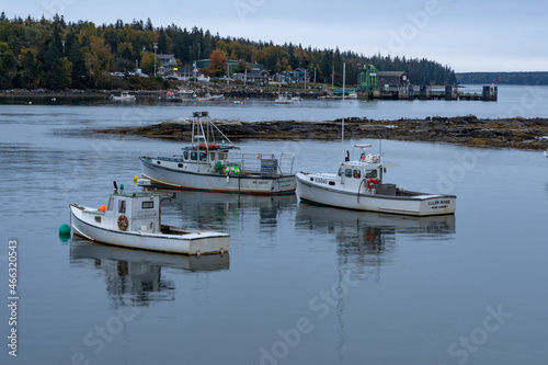 Bernard, ME - USA - Oct.15,2021:   Horizontal view of a three fishing boats moored in Bass Harbor during the Fall on Mt. Desert Island in Acadia National Park.