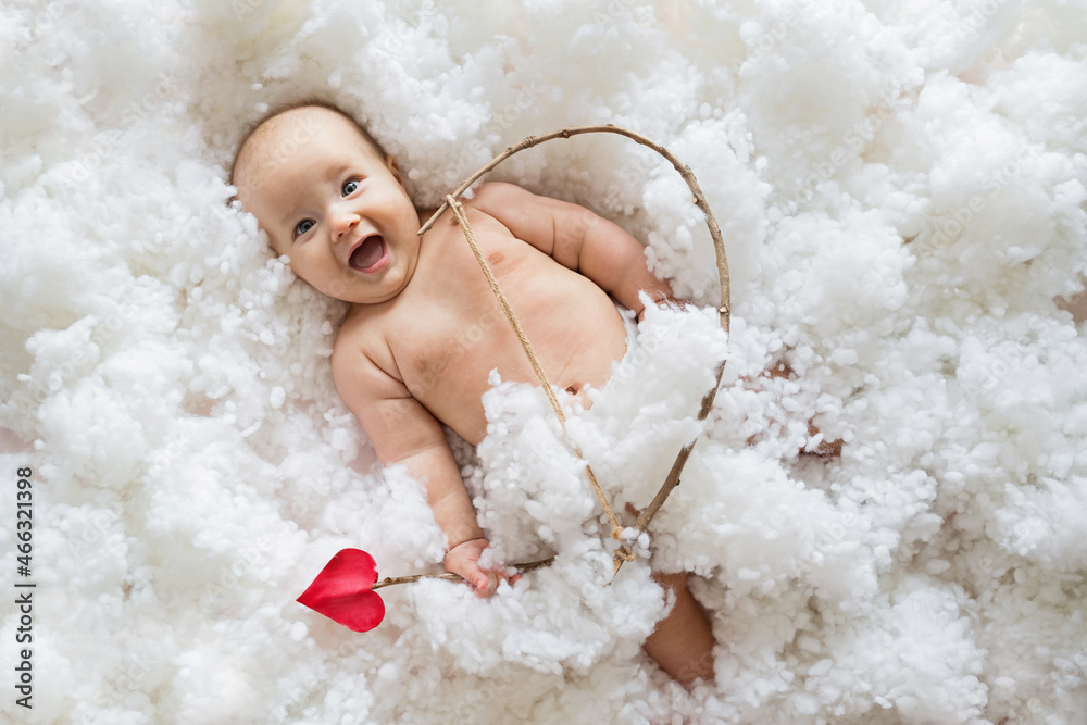 Cute smiling caucasian baby cupid on white clouds background with bow and heart arrow. Happy Valentines day concept. Cute smiling caucasian baby cupid on white clouds background with bow and heart arrow. Happy Valentines day concept.