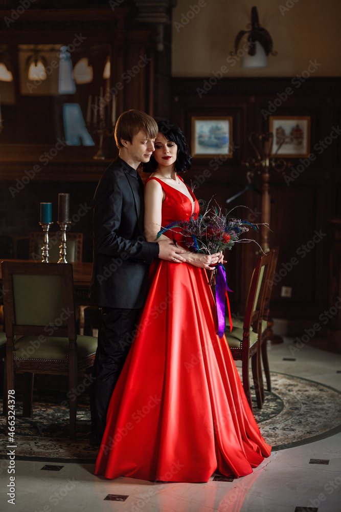 Naklejka premium woman in a red dress with a man in a black suite
