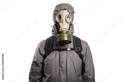 An isolated shot of a man dressed in a gas mask, a jacket with a hood, a backpack, gloves, looking into the camera. On a white isolated background