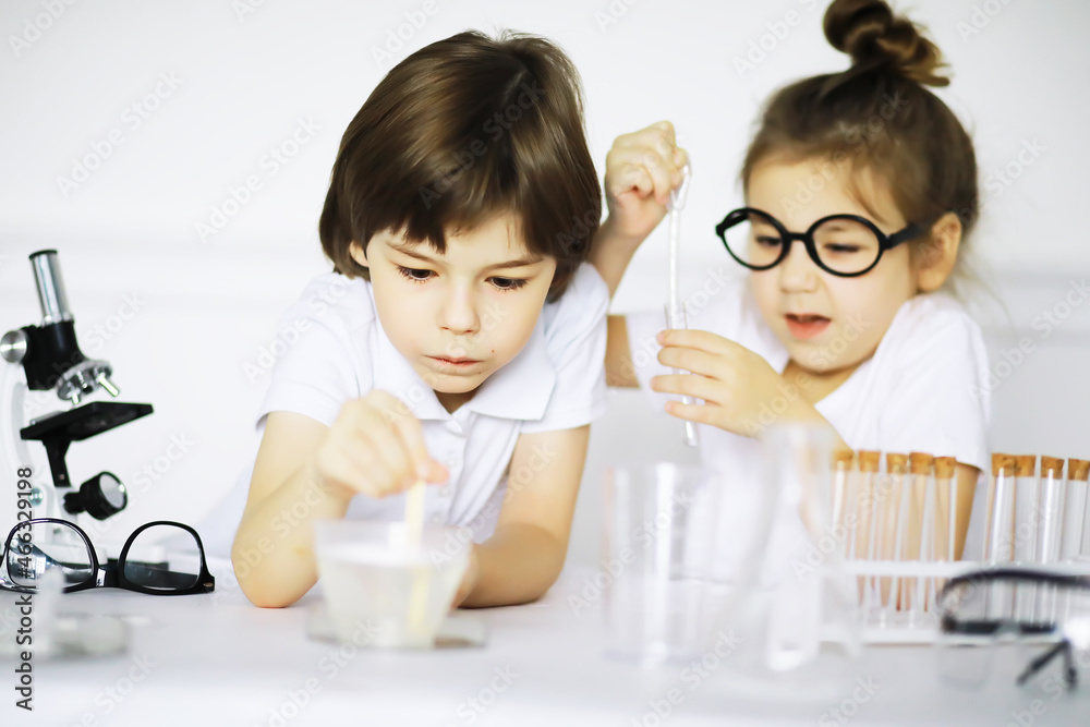 Two cute children at chemistry lesson making experiments on white background