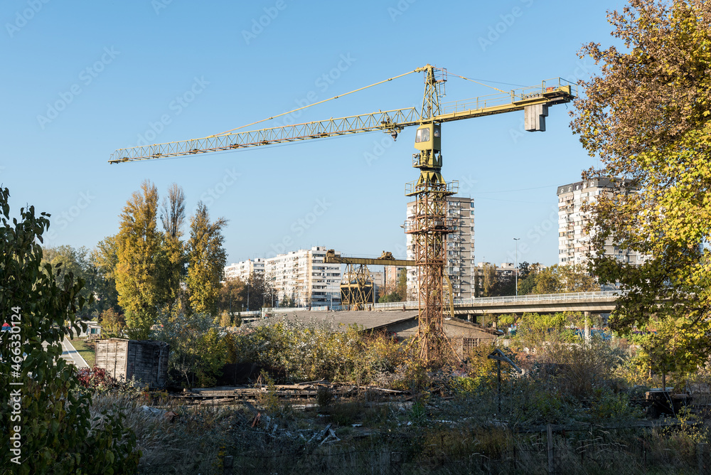 Old construction crane rusts from disuse in an abandoned company that went bankrupt due to lack of work. Construction business bankruptcy concept Old construction crane rusts from disuse in an abandoned company that went bankrupt due to lack of work. Construction business bankruptcy concept