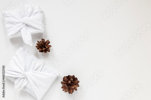 Furoshiki is a traditional Japanese tying technique. Flatlay White gifts with cones. Ecological gift wrapping. the concept of waste-free use of gift wrapping. © Александр Клюйко