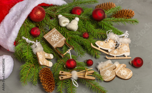Wooden Christmas decorations and Christmas ornament on the branches of a Christmas tree lying in a hat of Santa Claus.