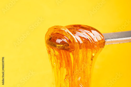 Quadro su tela amber yellow cannabis wax concentrate dripping from the dabbing tool close-up
