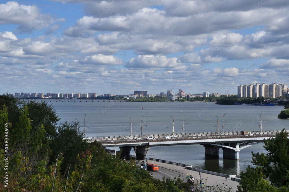 Panoramic view of the reservoir. A large bridge over the river and multi-storey residential buildings on the shore.