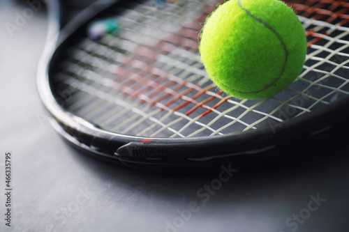Sport and healthy lifestyle. Tennis. Yellow ball for tennis and a racket on the table. Sports background with tennis concept. © alexkich