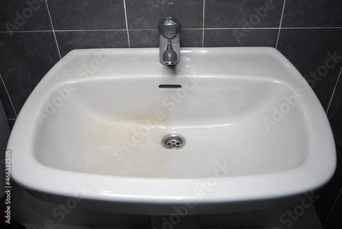 Dirty bathroom fixtures, white sink and chrome faucet. The difference before and after cleaning
