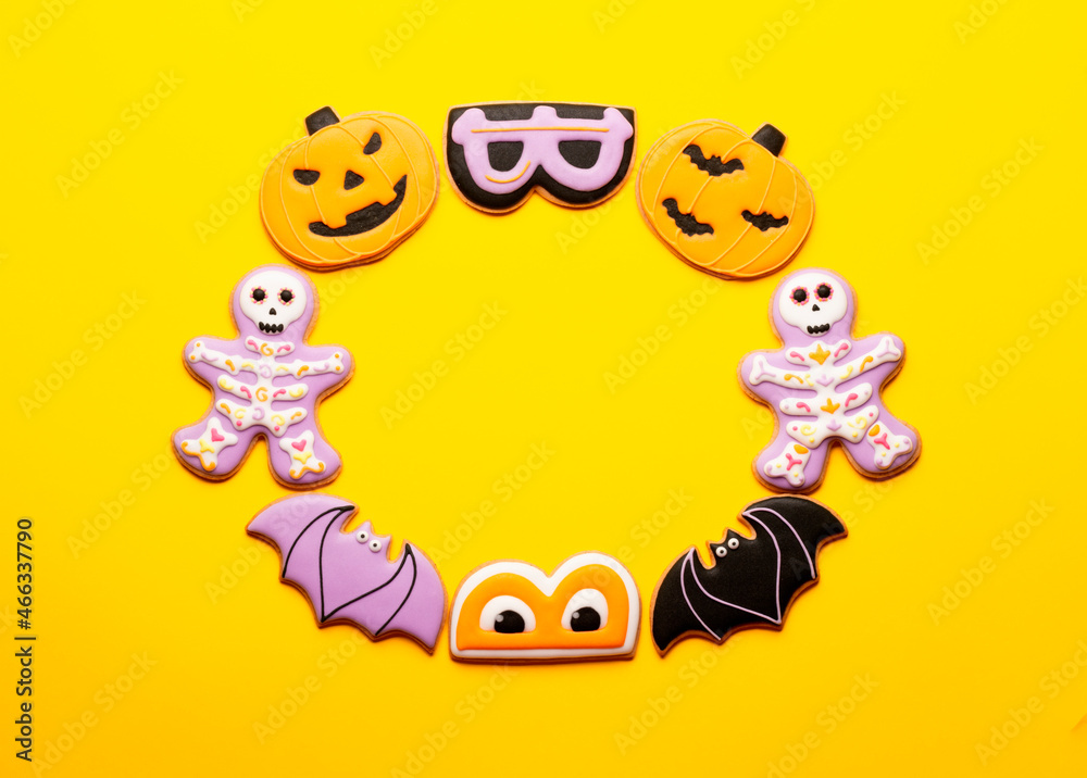 Homemade cookies bats, cute skeletons and pumpkins for Halloween on a yellow background