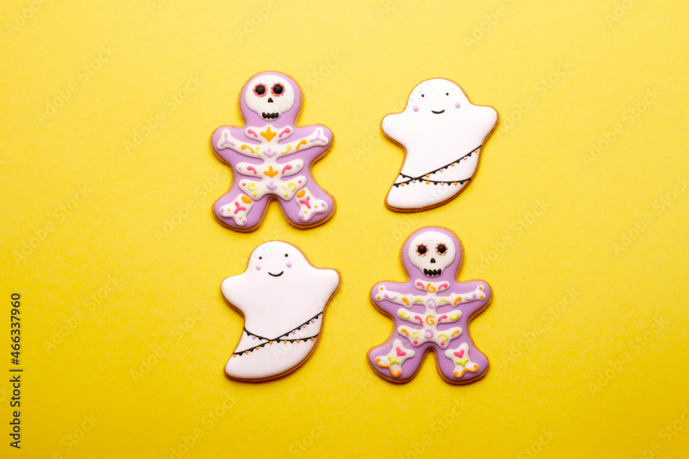 Homemade cookies cute skeletons and ghosts for Halloween on yellow background