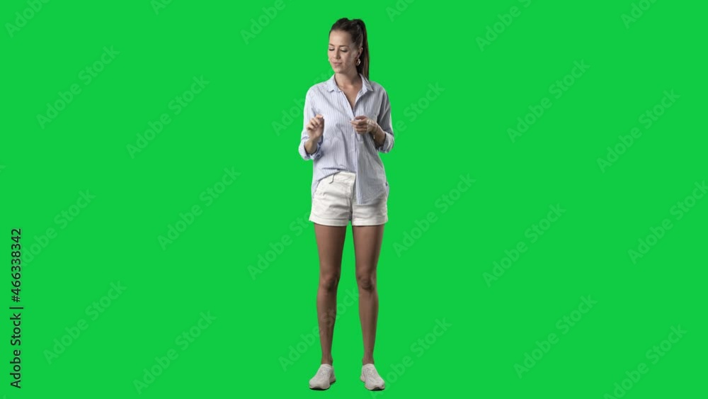 Stylish smart casual young woman in blue shirt using touch screen interactive technology gestures. Full body isolated on green screen background Stylish smart casual young woman in blue shirt using touch screen interactive technology gestures. Full body isolated on green screen background