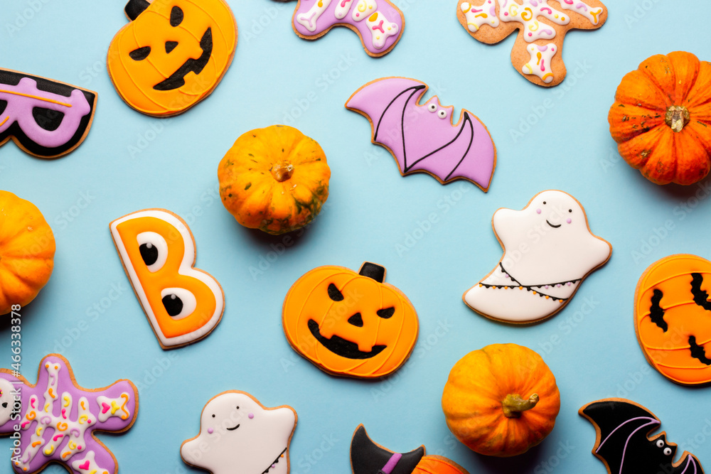 Homemade Halloween cookies, pumpkins, ghosts, bats, skeletons on blue background