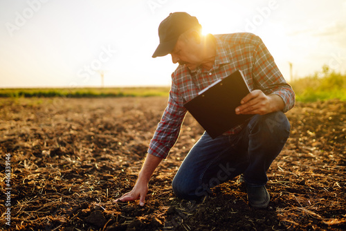 Fotografie Male hands touching soil on the field