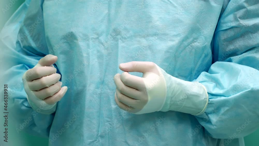 a nurse helps the surgeon put on gloves a nurse helps the surgeon put on gloves