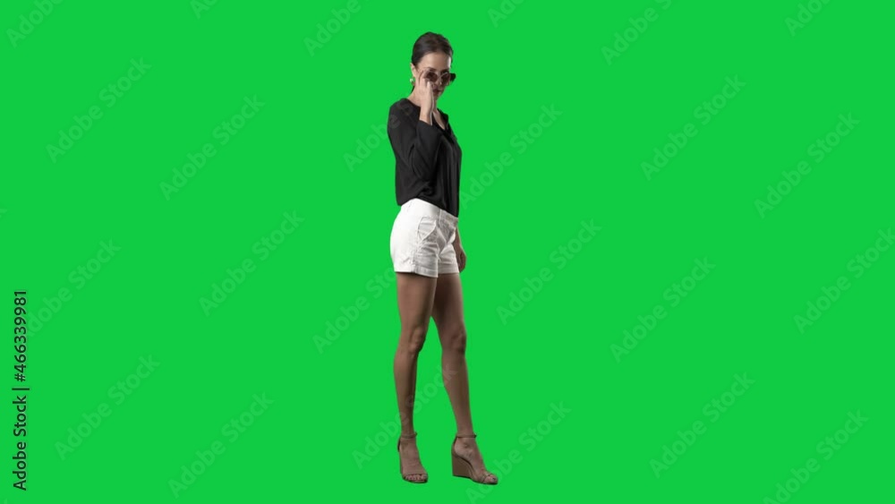 Stylish young ponytail elegant woman fashion model posing with sunglasses in slow motion. Full body isolated on green screen background Stylish young ponytail elegant woman fashion model posing with sunglasses in slow motion. Full body isolated on green screen background
