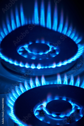 Closeup shot of blue fire from domestic kitchen stove top. Gas cooker with burning flames of propane gas. Industrial resources and economy concept.