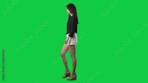 Serious confident young business casual style woman walking in hurry. Side view. Full body isolated on green screen background