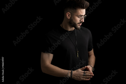 sexy young fashion man with glasses looking to side and touching fingers photo