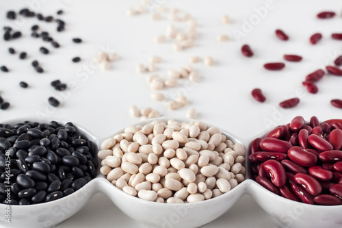 Assortment of beans in a white bowl on white background photo