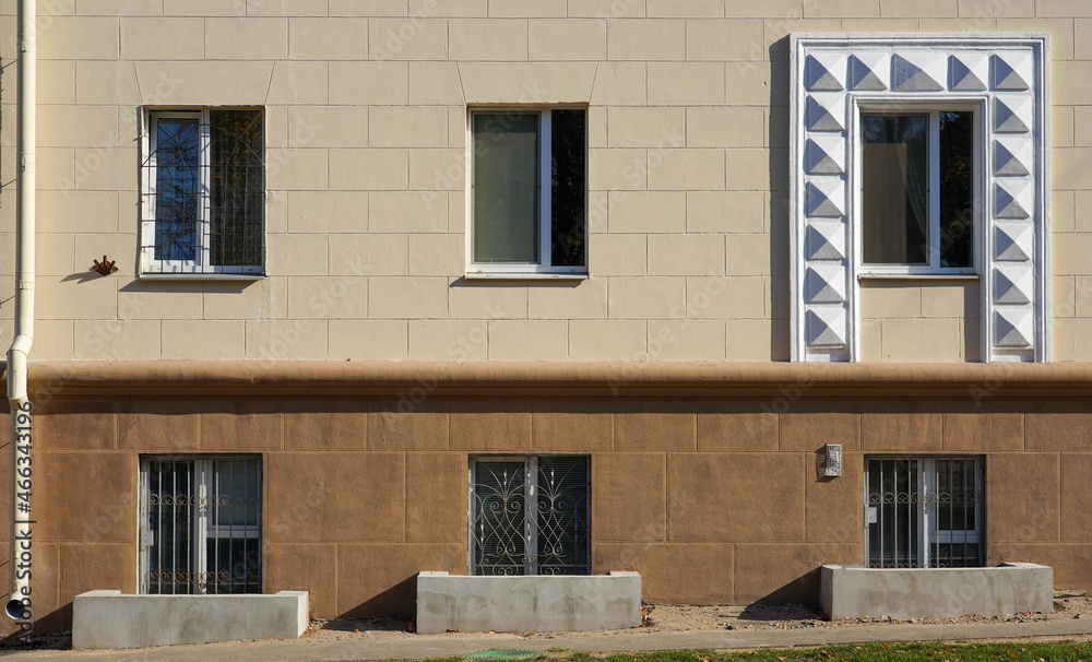 Fototapeta premium Photo of a building with a beige-brown wall and windows in the city