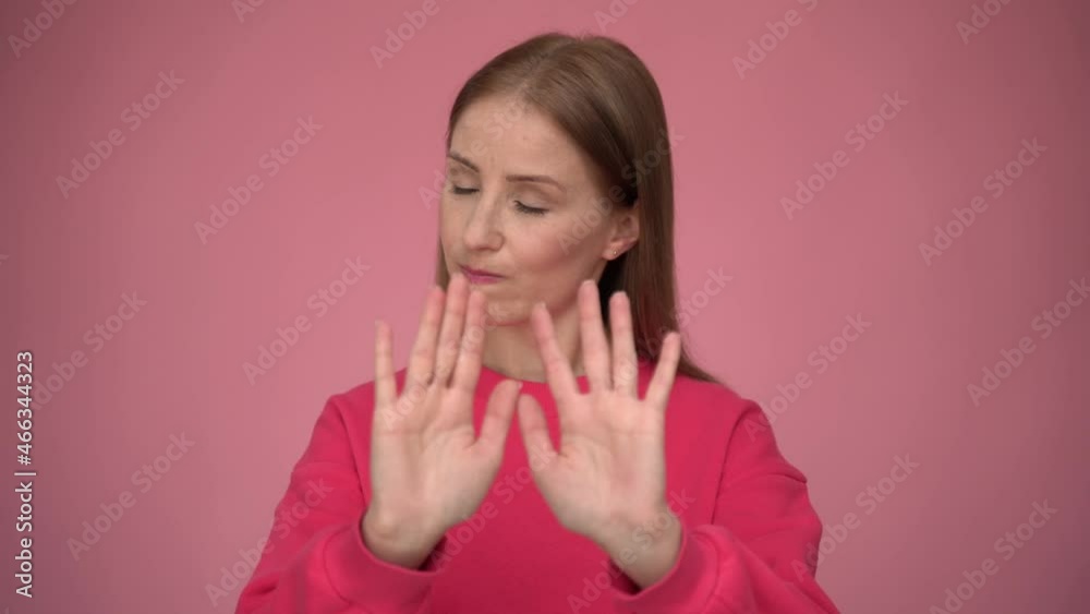 Serious concerned woman making stop gesture showing palm of hand, conflict prohibition warning about danger, stop bullying. Indoor studio shot isolated on pink background Serious concerned woman making stop gesture showing palm of hand, conflict prohibition warning about danger, stop bullying. Indoor studio shot isolated on pink background