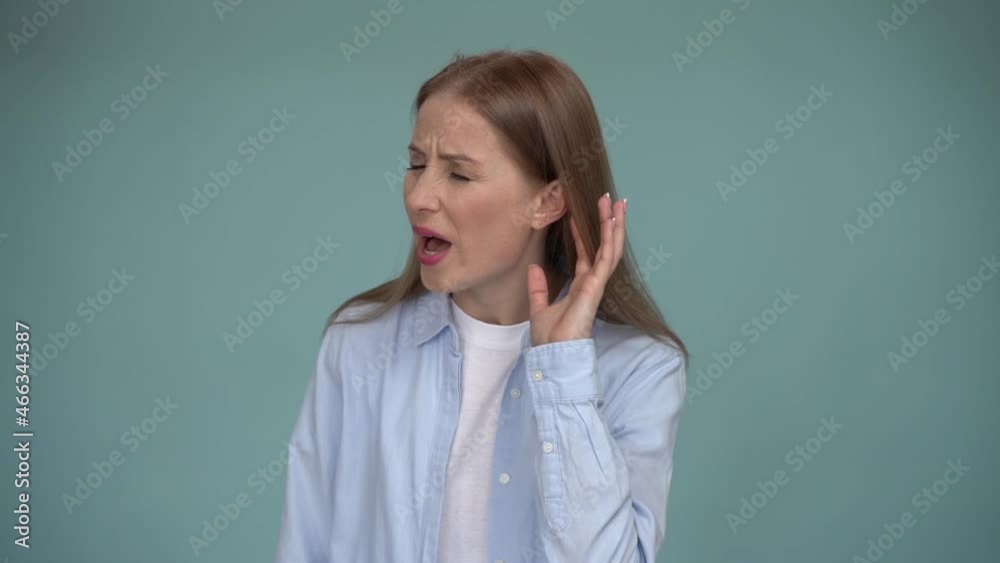 Portrait of attentive brunette woman holding hand near ear trying to listen quiet conversation, overhearing gossip. Indoor studio shot, isolated on blue background Portrait of attentive brunette woman holding hand near ear trying to listen quiet conversation, overhearing gossip. Indoor studio shot, isolated on blue background