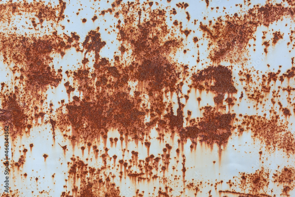 The surface of a rusty metal sheet with traces of old gray paint.  Textured background