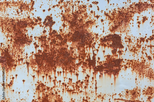 The surface of a rusty metal sheet with traces of old gray paint. Textured background