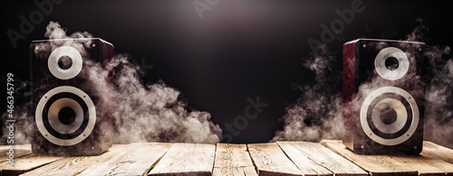 Photos Two smoky audio speakers on wooden planks in the dark