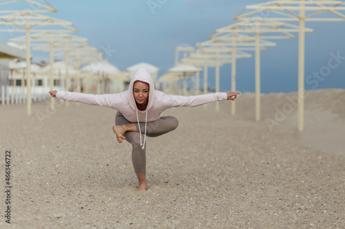  girl in pink hoodie make yoga balance poses