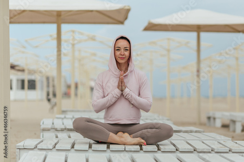 woman meditating in yoga pose on the beach