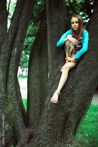 Teenage girl sitting in a tree.