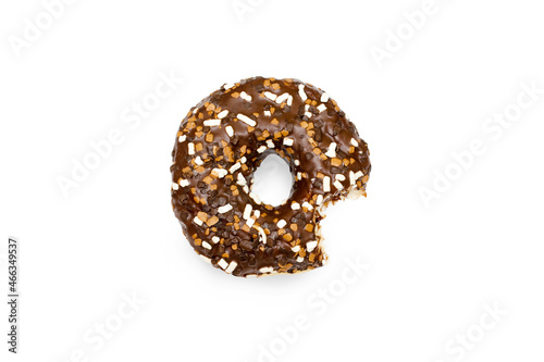 Creative concept of biting eating delicious sweet sugar brown black doughnut donut with glaze on white background. Top view flat lay unhealthy dessert, Food concept, mock up