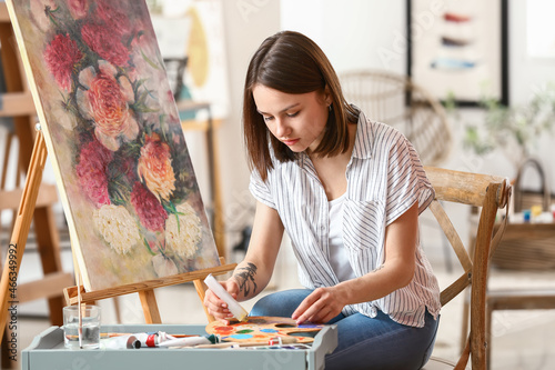 Young female artist paintin...